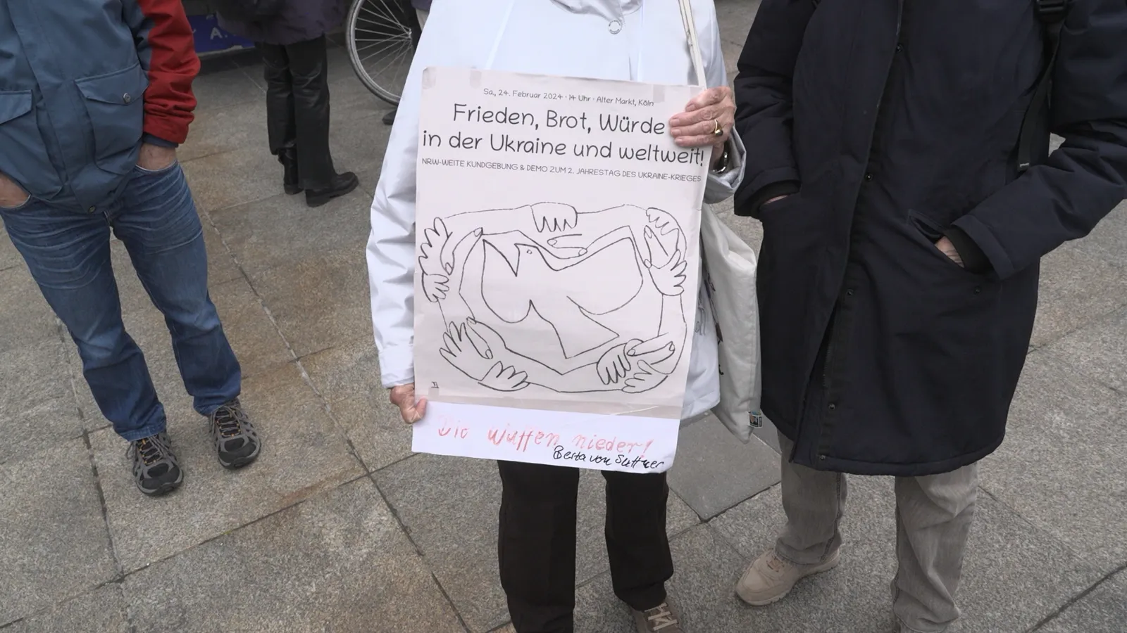 Demonstrant hält Schild mit Friedensbotschaft beim Ostermarsch in Köln