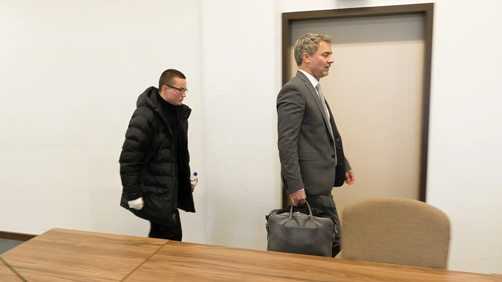 Angeklagter und Begleitung betreten Gerichtssaal