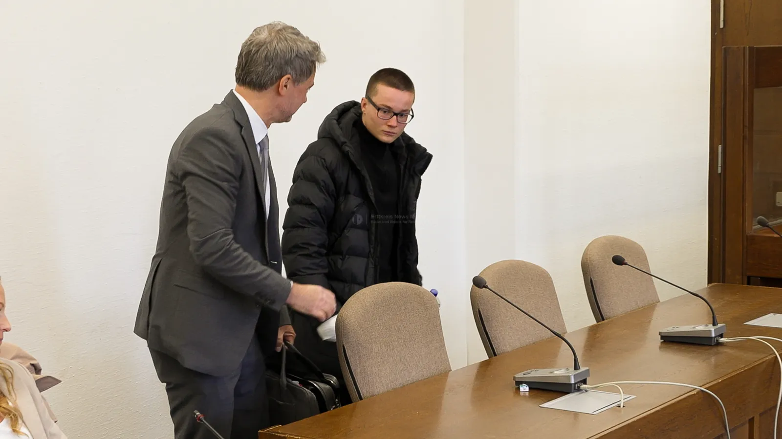 Junger Mann mit Rechtsbeistand im Gerichtssaal