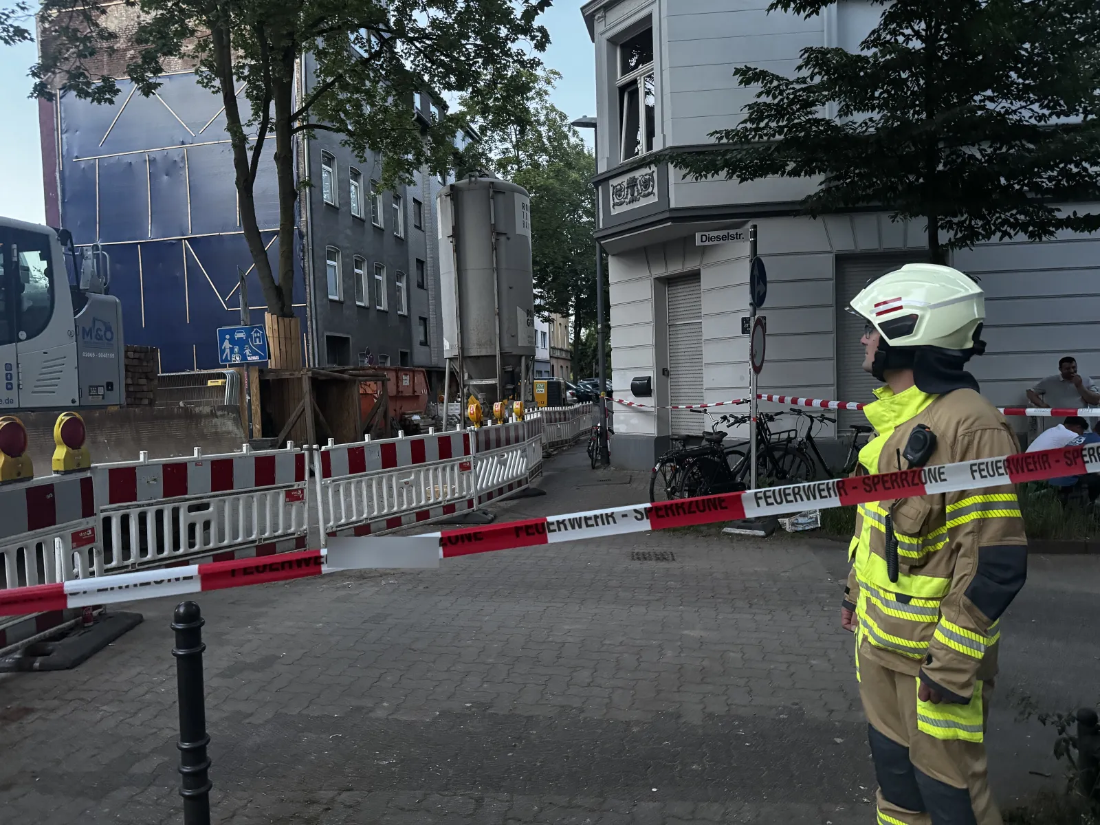 Absperrung und Feuerwehrmann vor Baugebiet in Köln