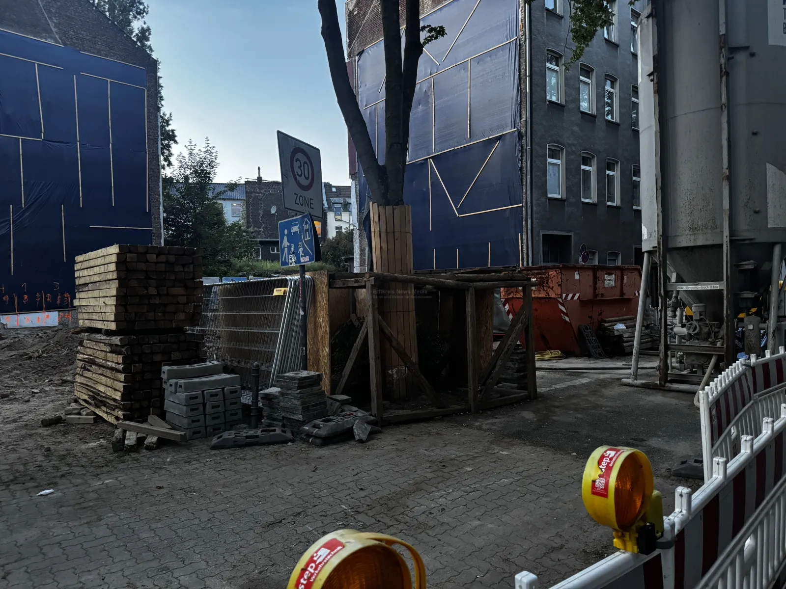 Bauarbeiten mit Absperrungen und Schutzmaßnahmen an Gebäude