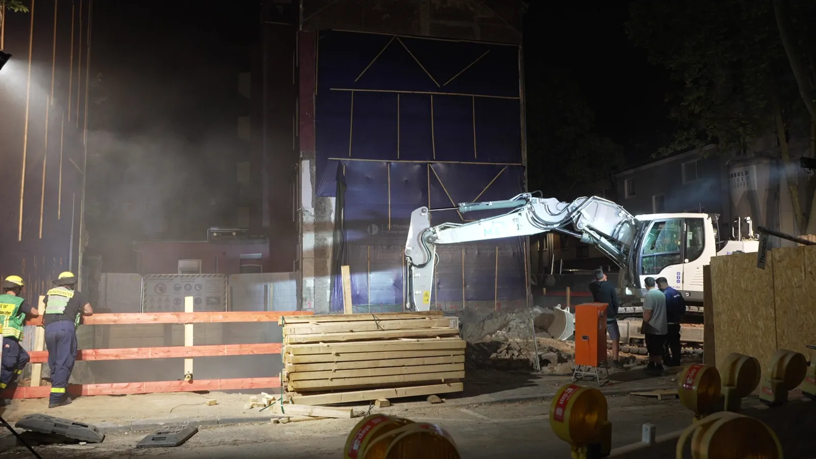 Absperrung und Bagger bei nächtlichem Einsatz an Baugrube