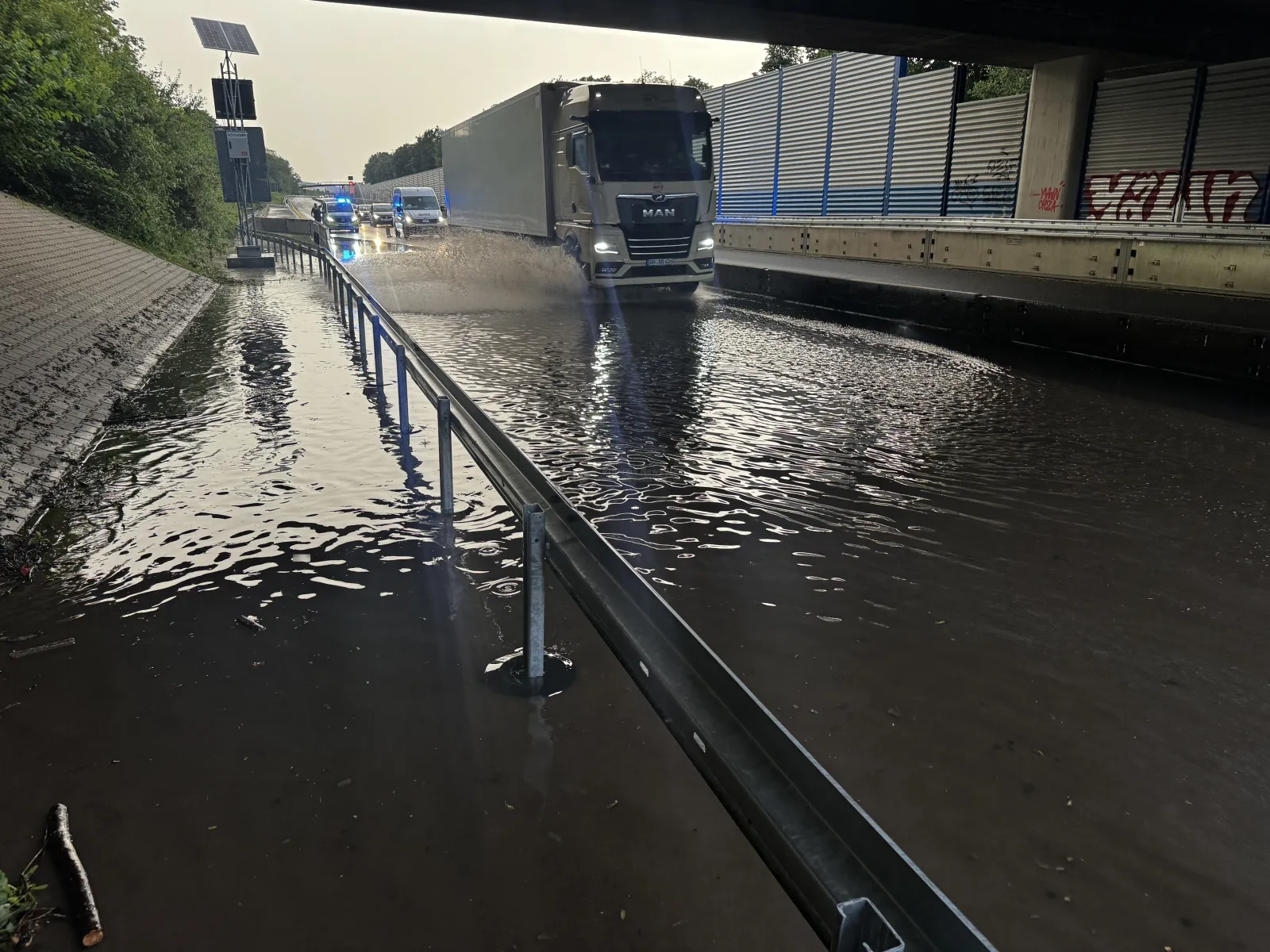 Überflutung unter Brücke mit LKW und Feuerwehrfahrzeugen