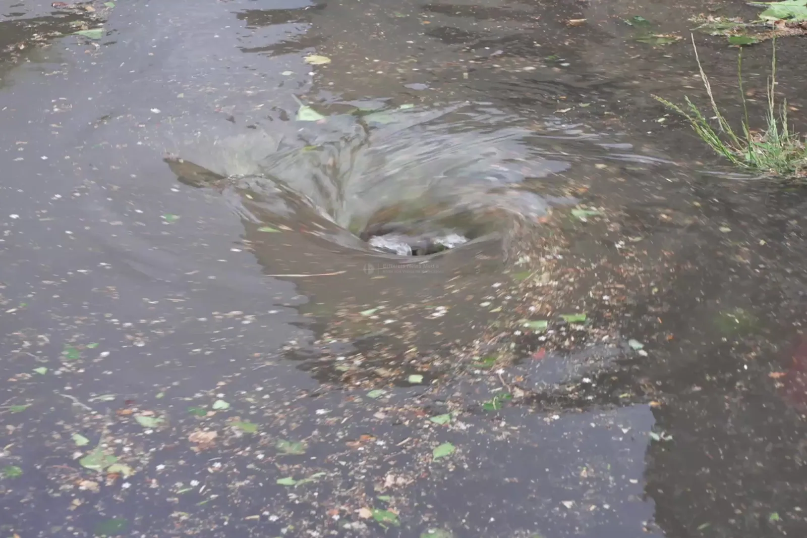 Überflutete Straße mit Wasserstrudel nach Unwetter