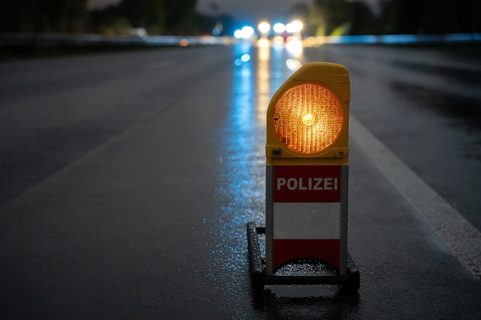Polizei-Warnleuchte auf gesperrter Autobahn bei Dunkelheit