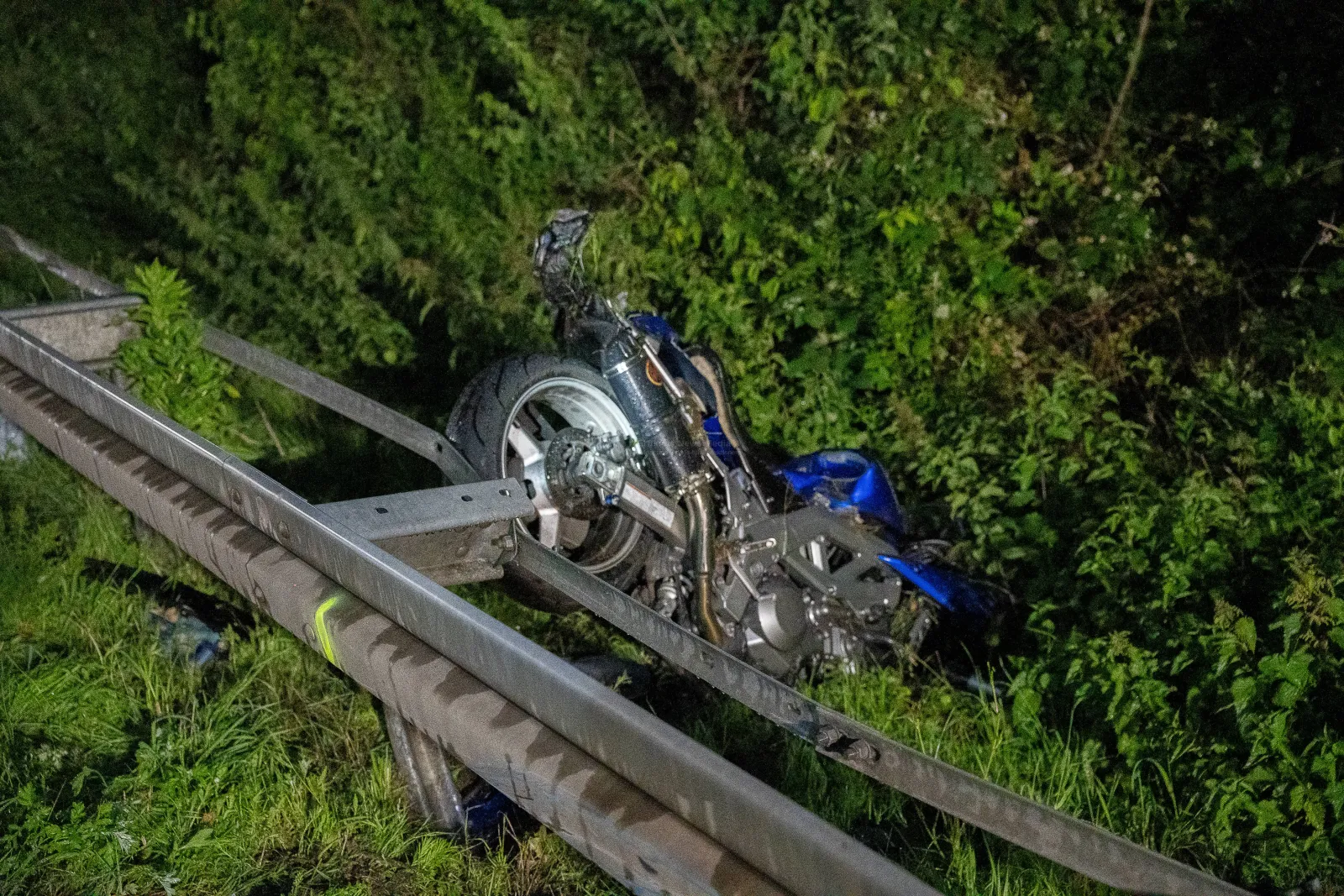 Verunfalltes blaues Motorrad an Leitplanke der A555