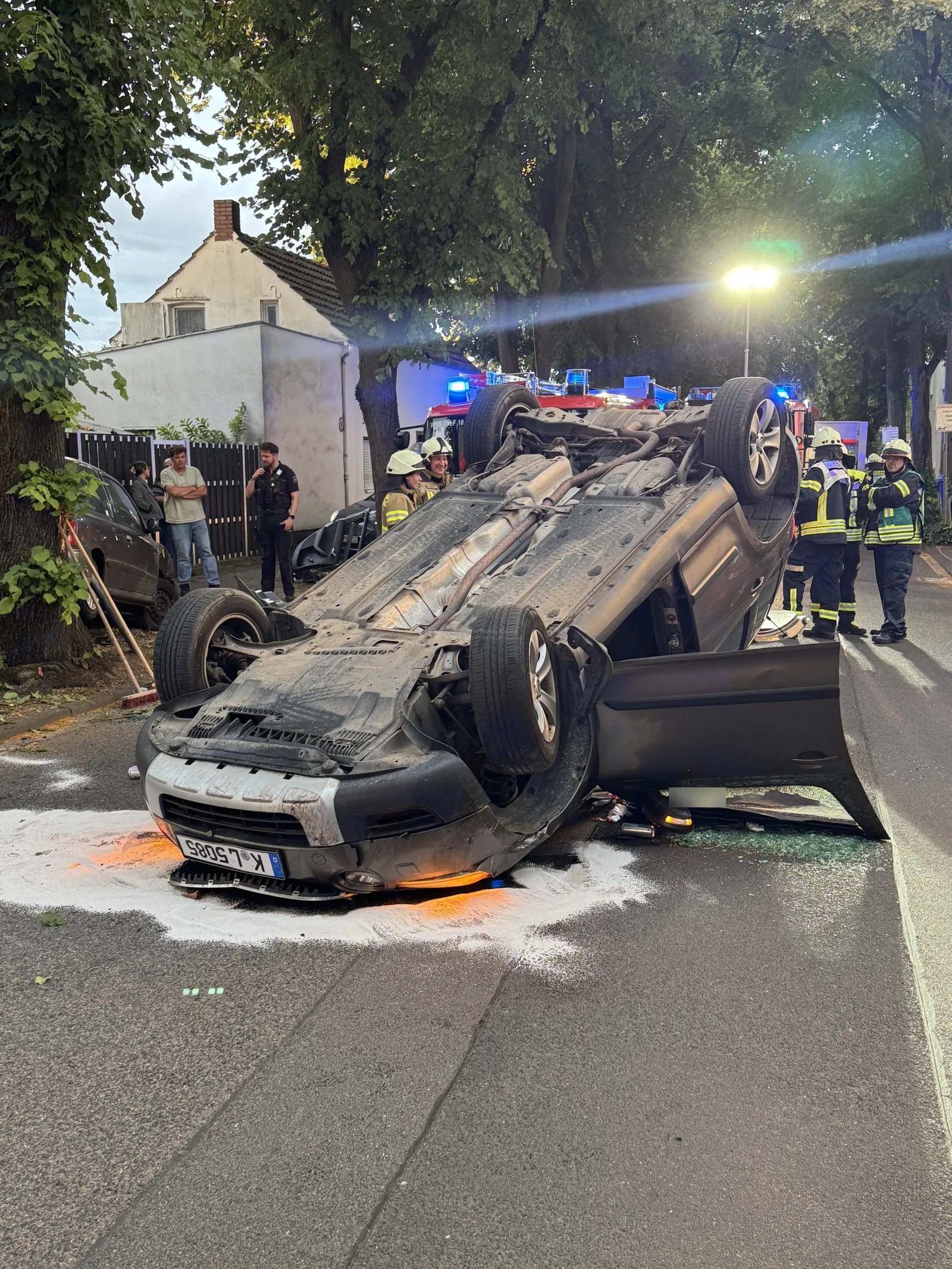 Auf Pkw überschlagenes Fahrzeug auf Kölner Straße mit Einsatzkräften