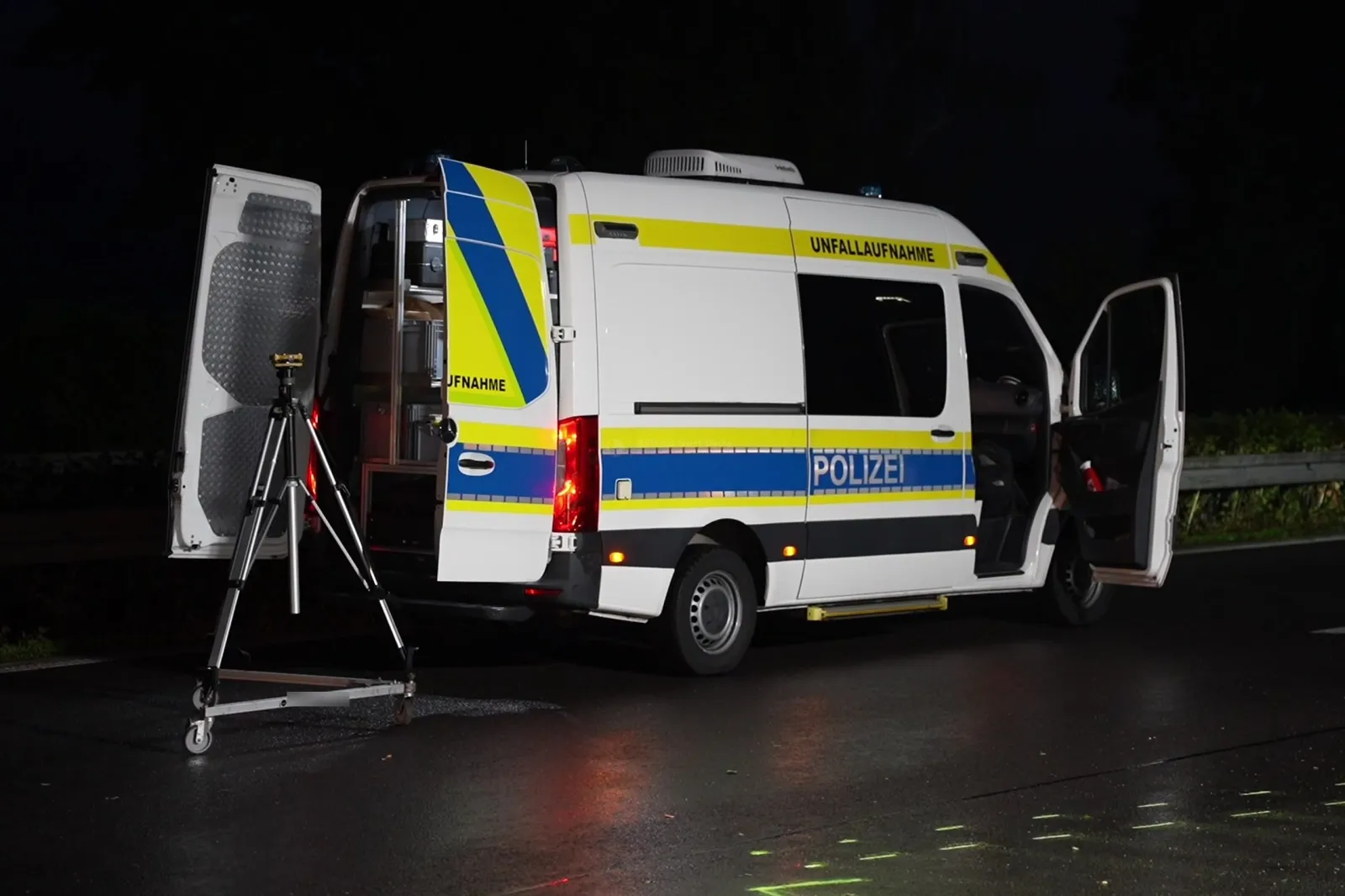 Polizeifahrzeug Unfallaufnahme auf nässer Fahrbahn bei Nacht