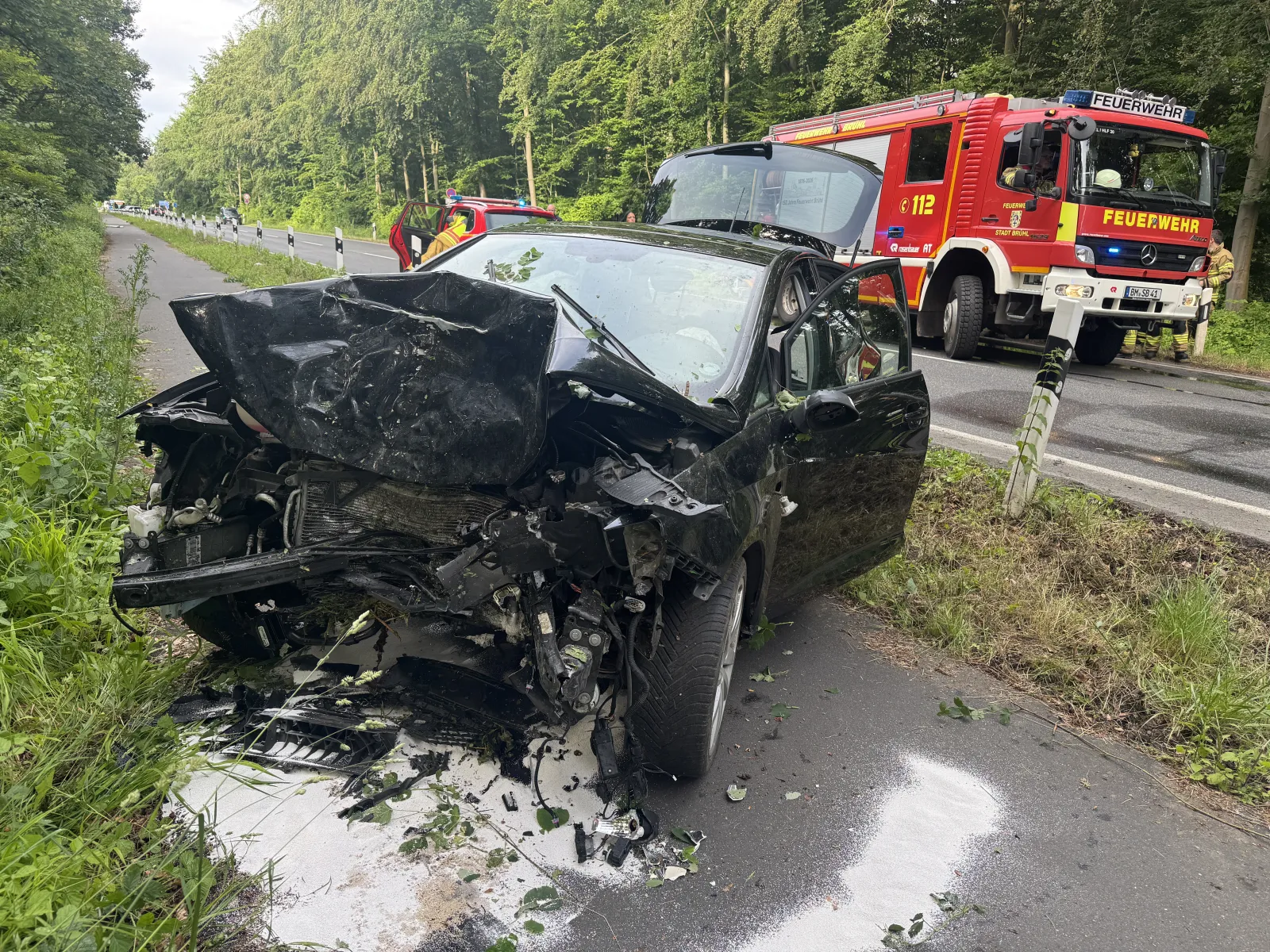 Schwer beschädigter PKW nach Unfall in Brühl neben Löschfahrzeug