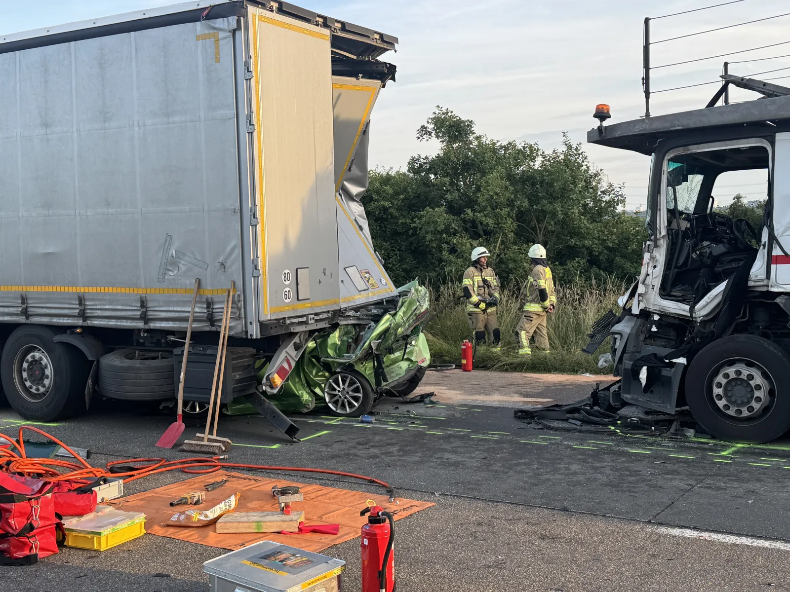 Zerstörter Kleinwagen unter LKW bei Unfall auf A4 Köln