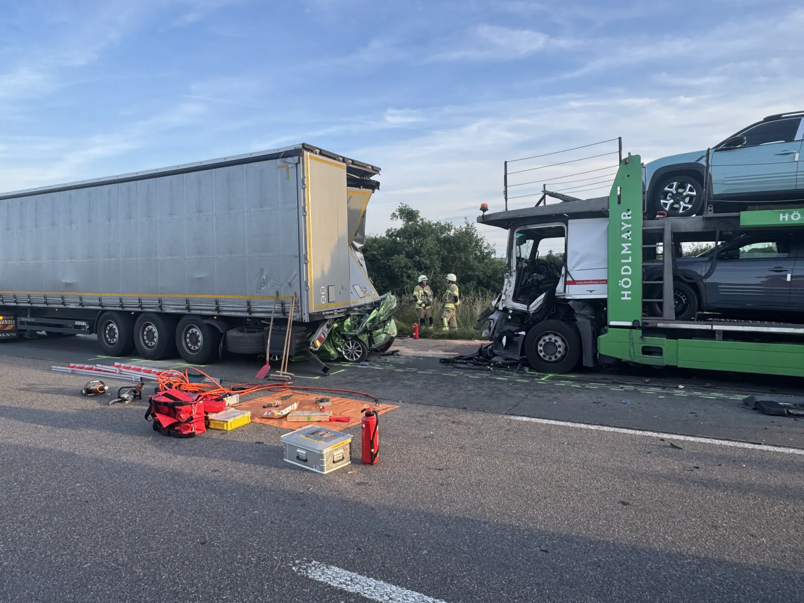 Unfallstelle auf der A4 mit zerquetschtem Kleinwagen zwischen Lkw und Autotransporter