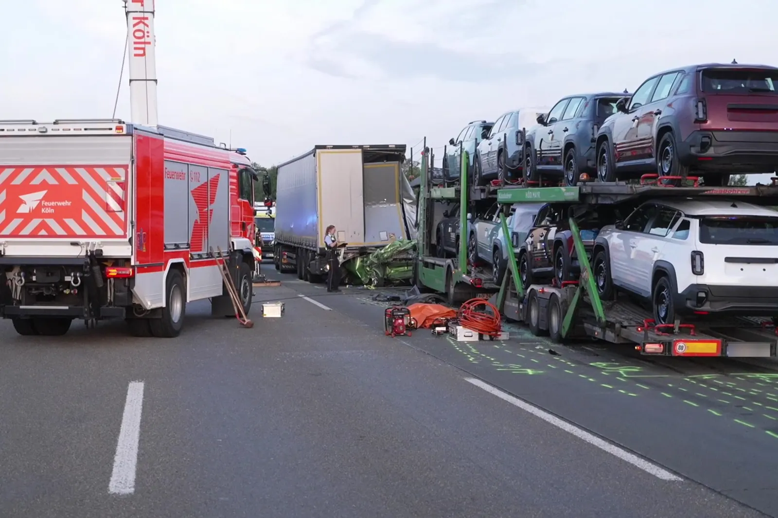Unfallstelle mit Feuerwehrfahrzeug, Autotransporter und zerstörtem Pkw auf der A4