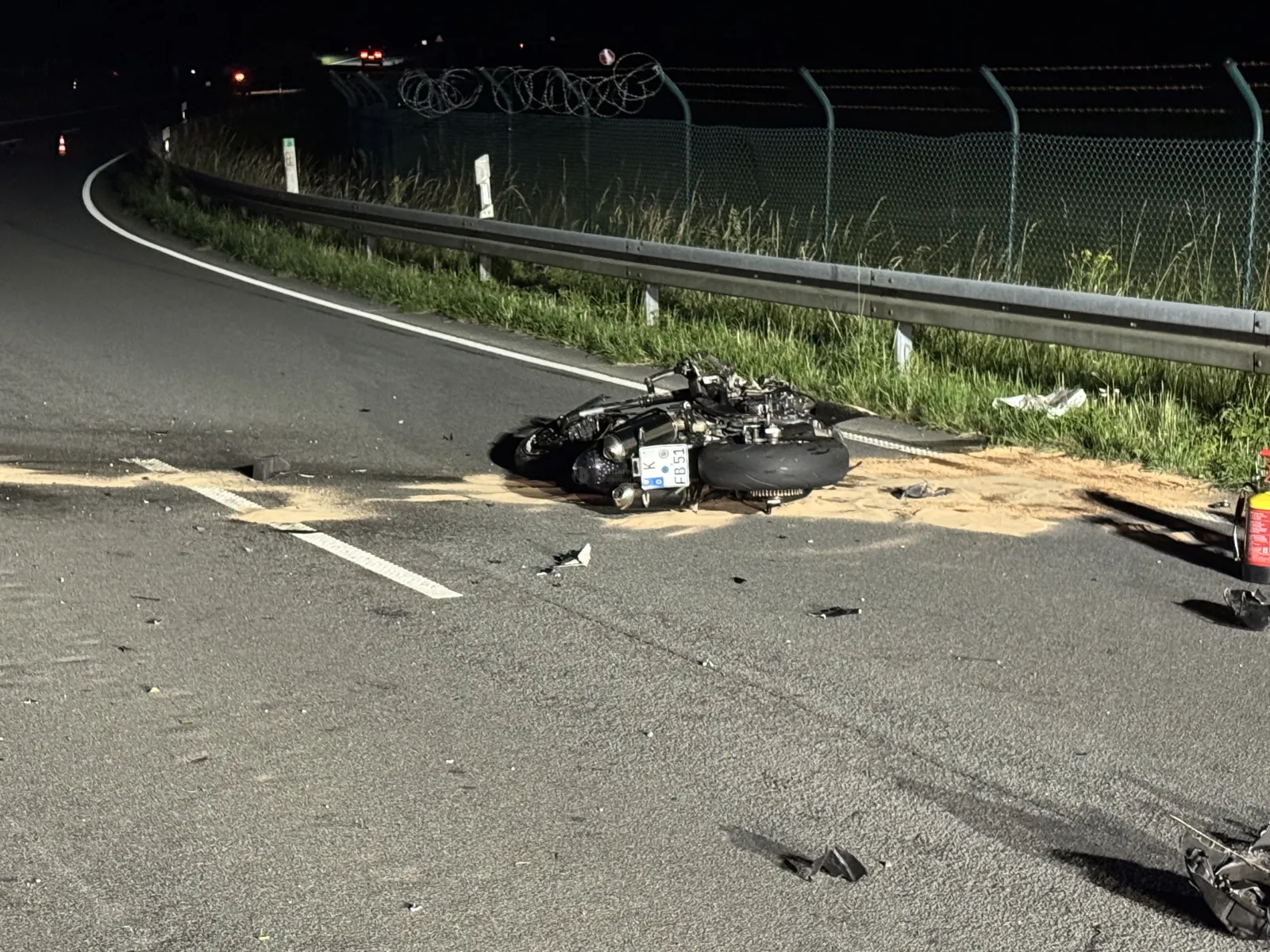 Liegend beschädigtes Motorrad nach Unfall auf Straße