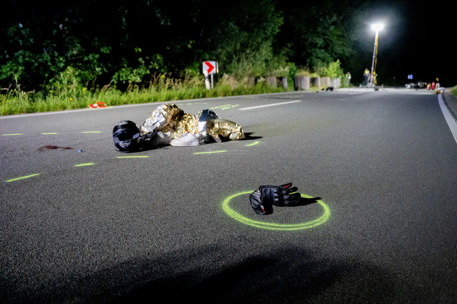 Motorradunfall mit Ausrüstung auf Straße bei Nacht