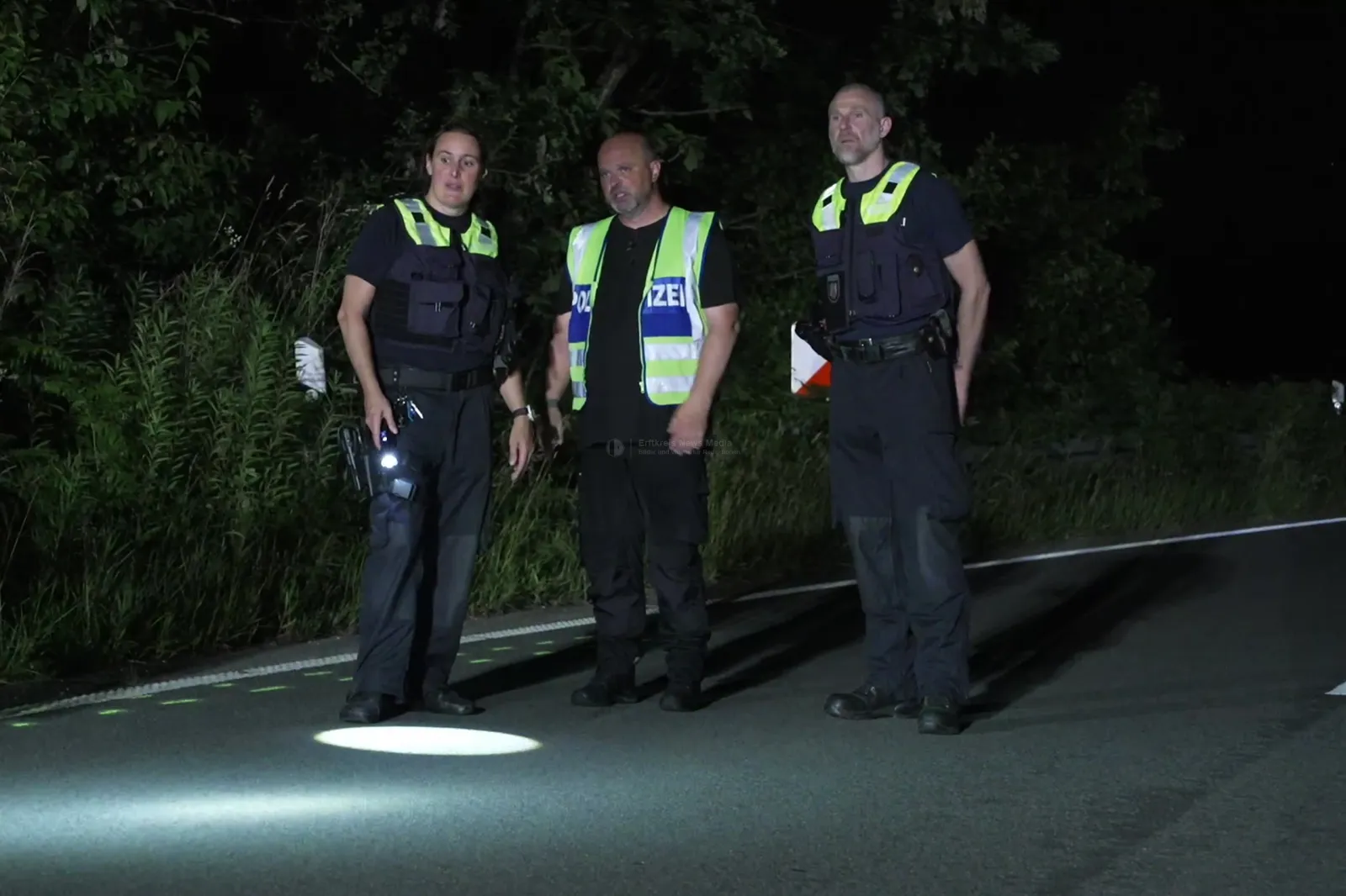 Polizeibeamte untersuchen Unfallort auf der alten Kölner Straße bei Nacht