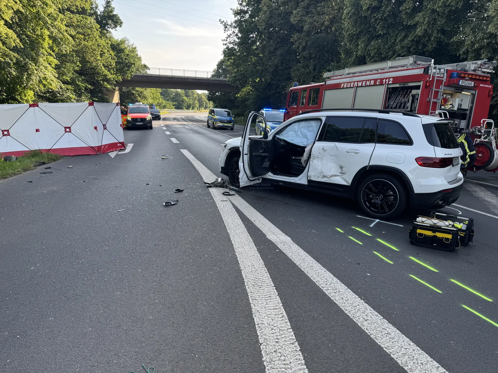 Unfallstelle mit weißem SUV und Rettungskräften auf B477 in Bergheim
