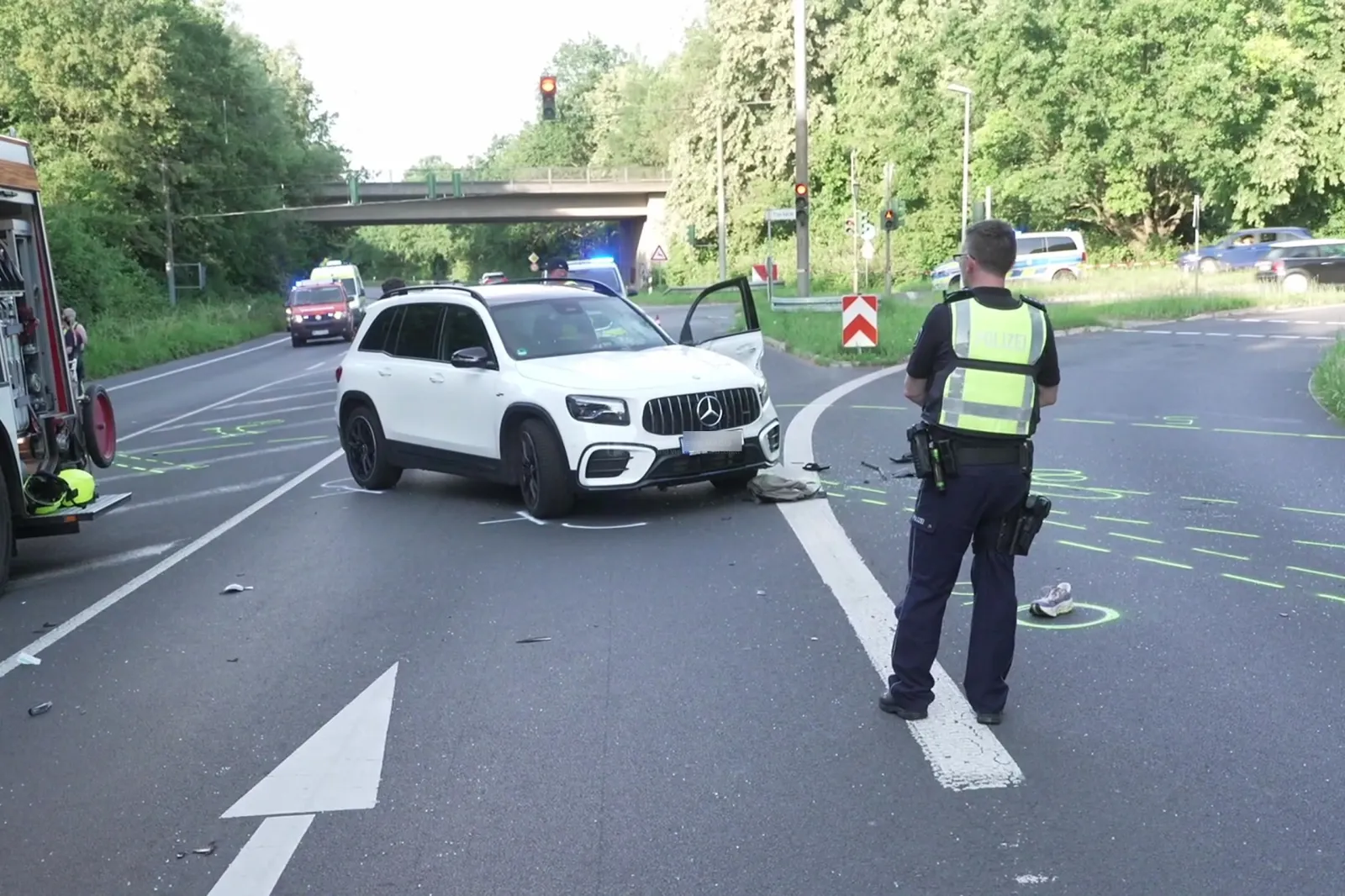 Unfallstelle mit weißem SUV und Polizeibeamtem auf der B477 in Bergheim