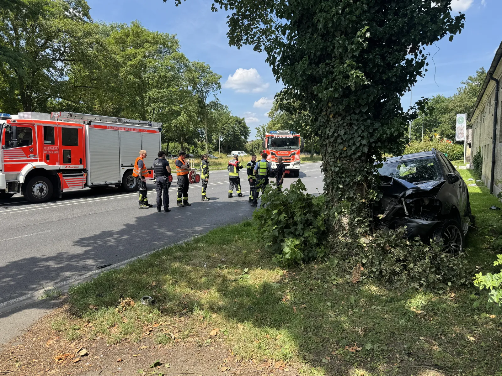 Unfallfahrzeug frontal mit Feuerwehr und Polizei auf Straße in Wesseling