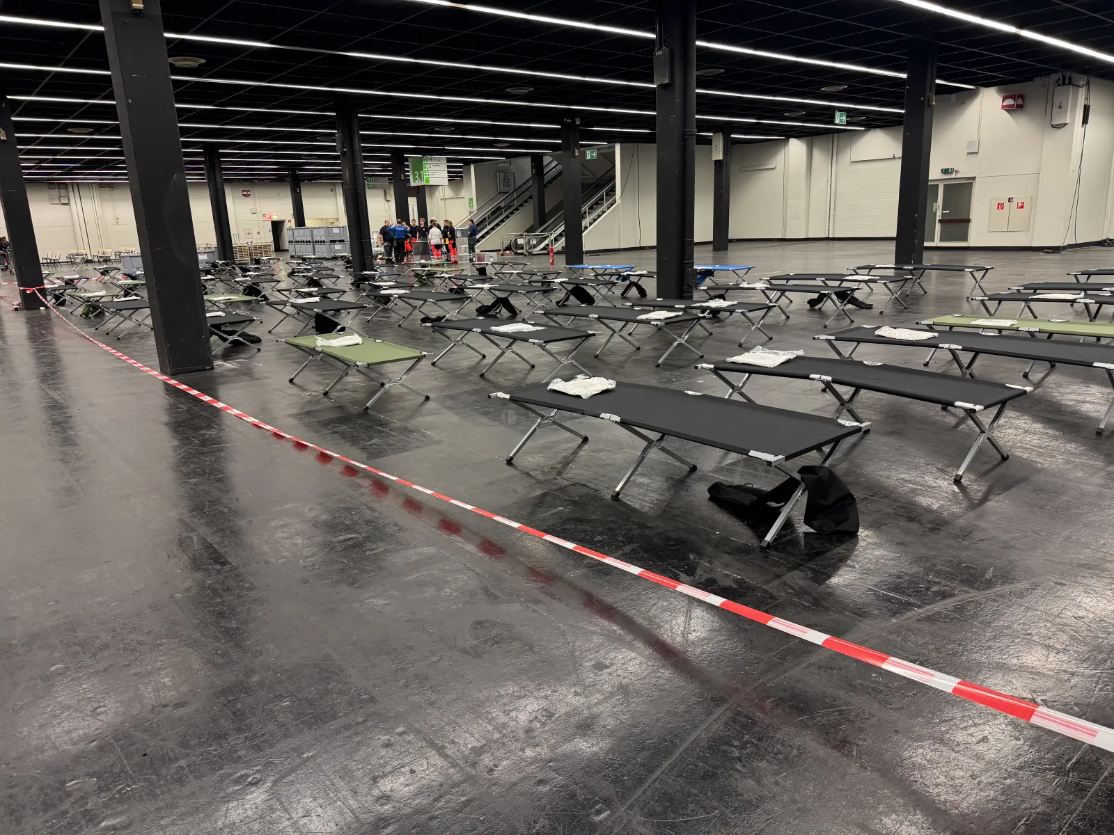Temporäre Patientenversorgungsstelle mit Feldbetten in großer Halle