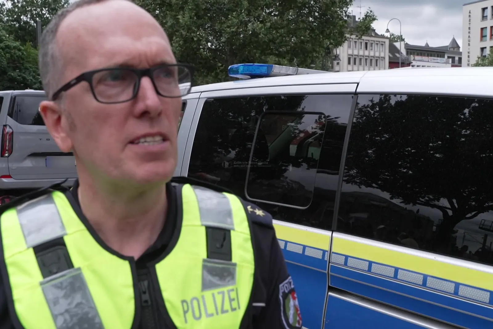 Polizist im Einsatz mit Polizeiauto bei ColognePride 2026 in Köln
