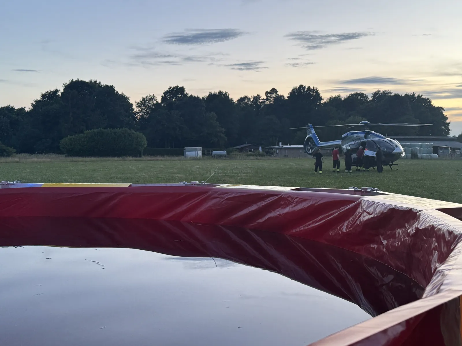 Feuerwehrmannschaft am Polizeihubschrauber auf Feld bei Rösrath