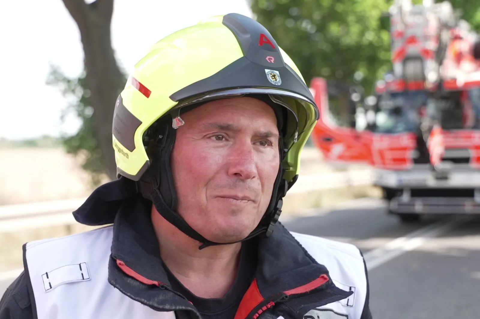 Einsatzkraft der Feuerwehr mit gelbem Helm an Unfallstelle auf der B477