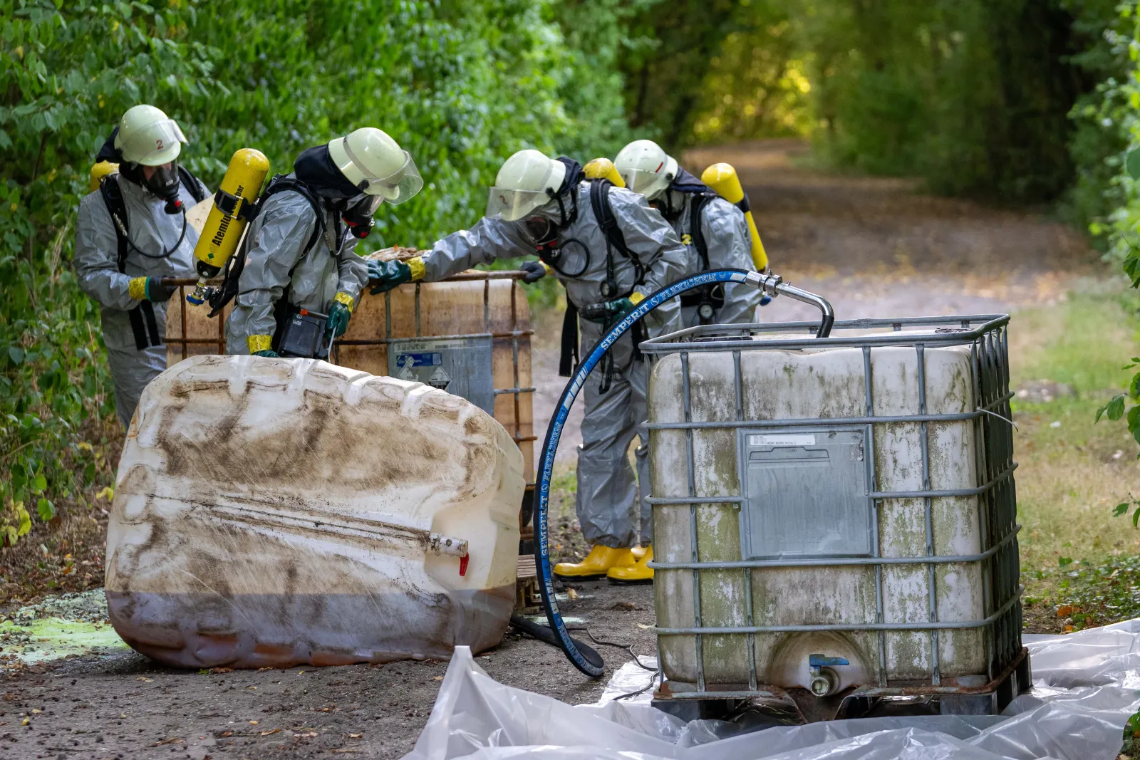 Feuerwehr bei Einsatz wegen ausgelaufener Flüssigkeit auf Waldweg