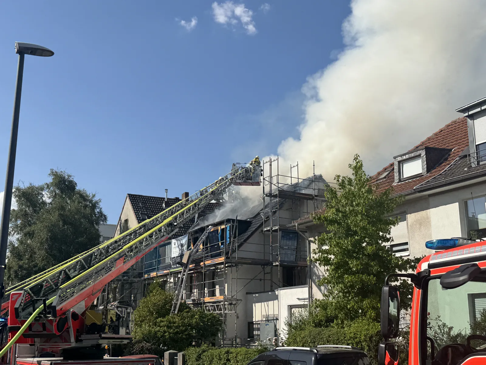 Brand eines Mehrfamilienhauses mit Feuerwehr im Einsatz in Köln