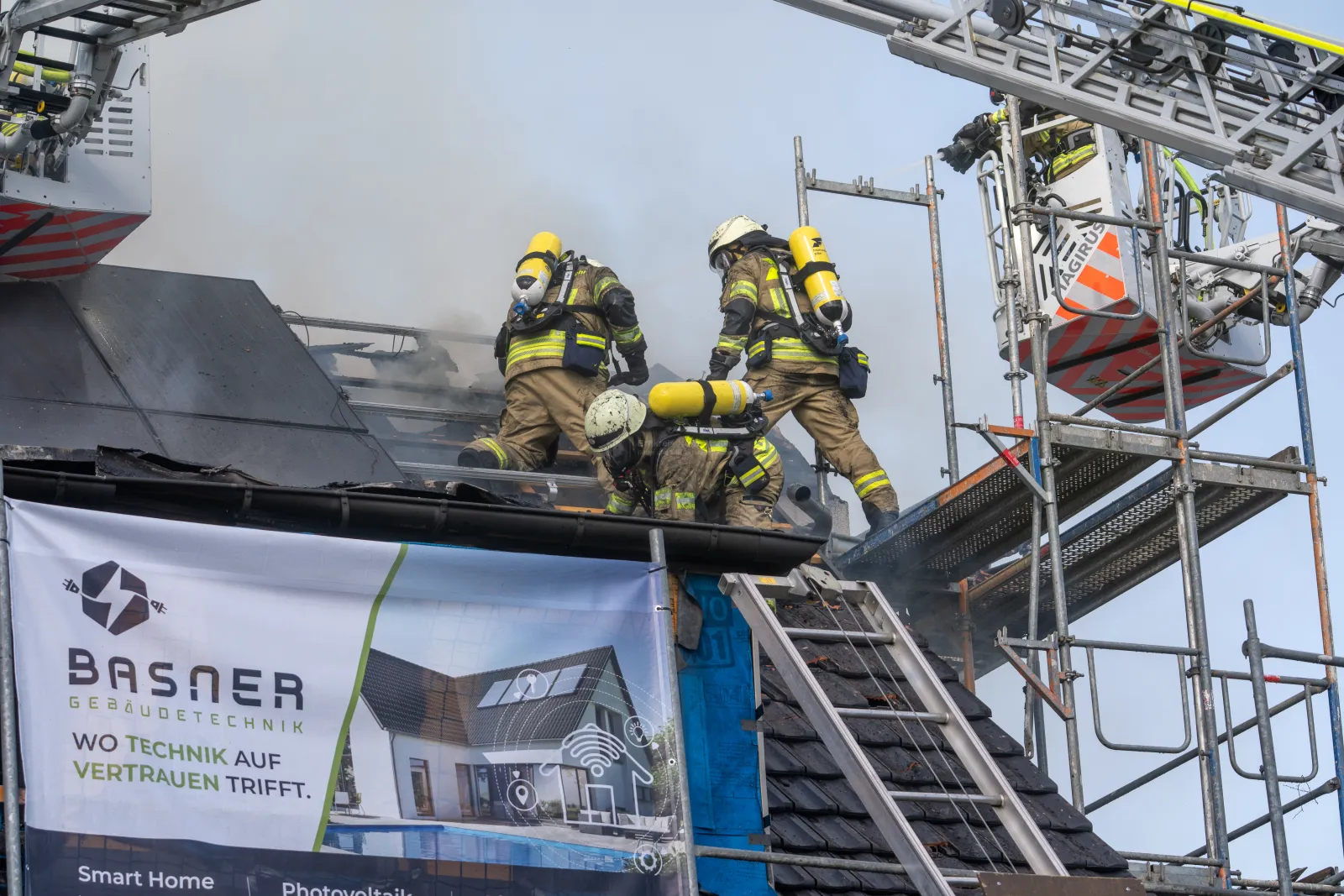 Feuerwehrleute bekämpfen Brand auf Baustellendach in Köln