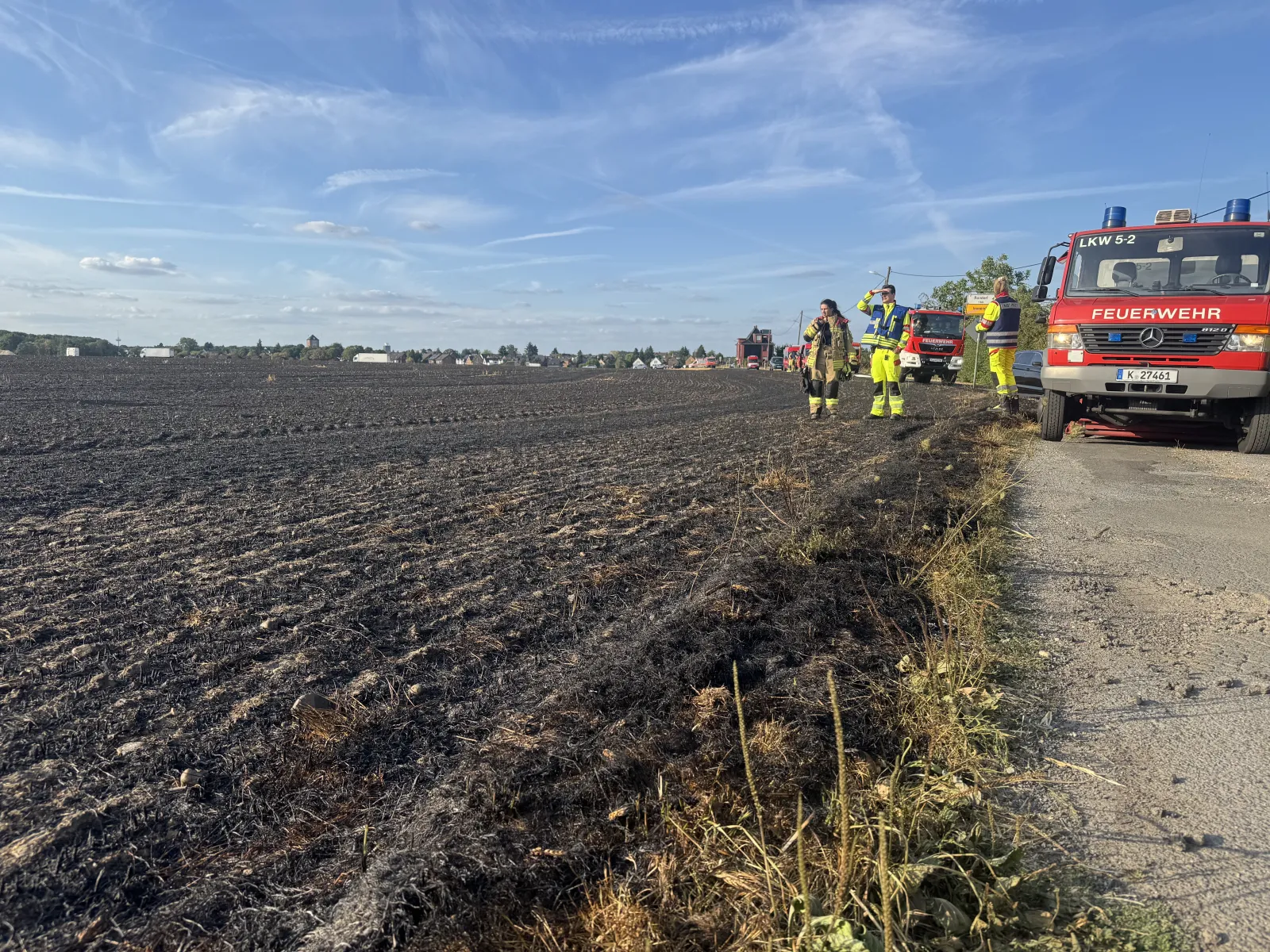 Abgebranntes Getreidefeld mit Feuerwehr in Köln Immendorf
