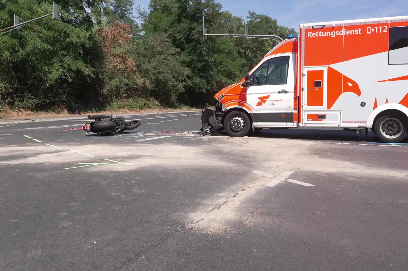 Unfallstelle mit verunglücktem Motorrad und Rettungswagen in Köln-Longerich