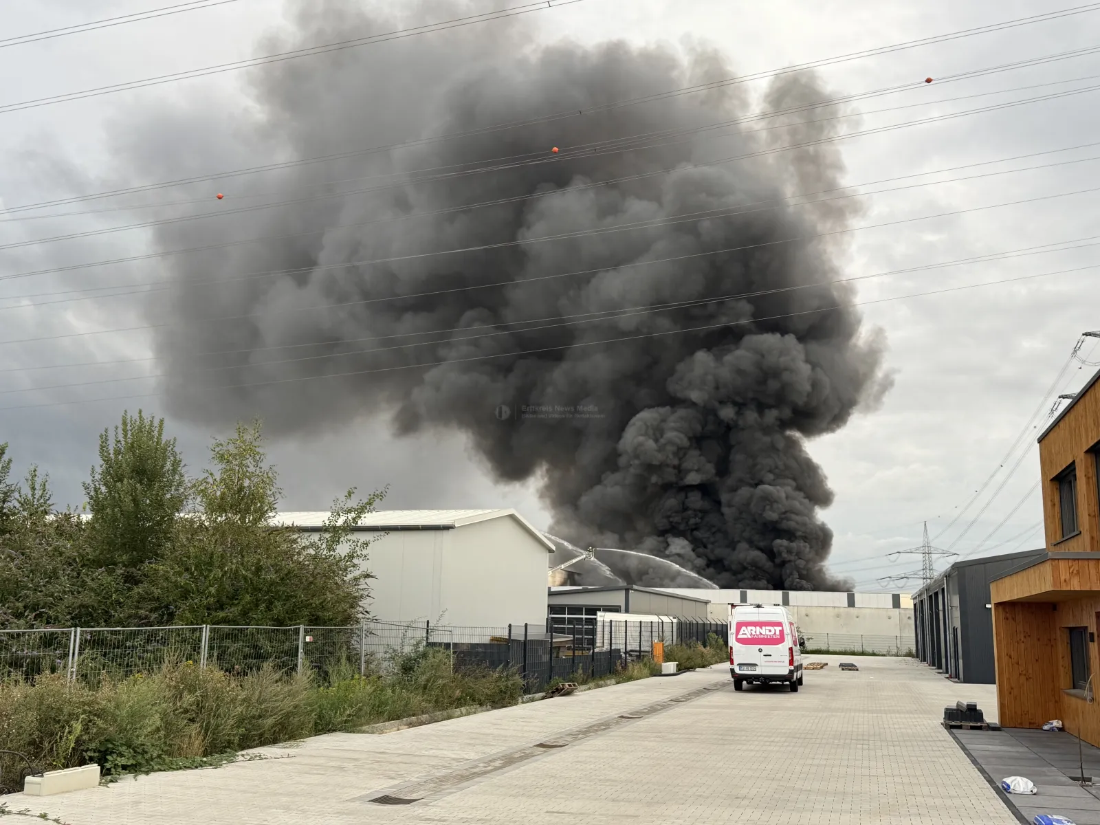 Große Rauchwolke über Lagerhalle in Bergheim während Feuerwehreinsatz