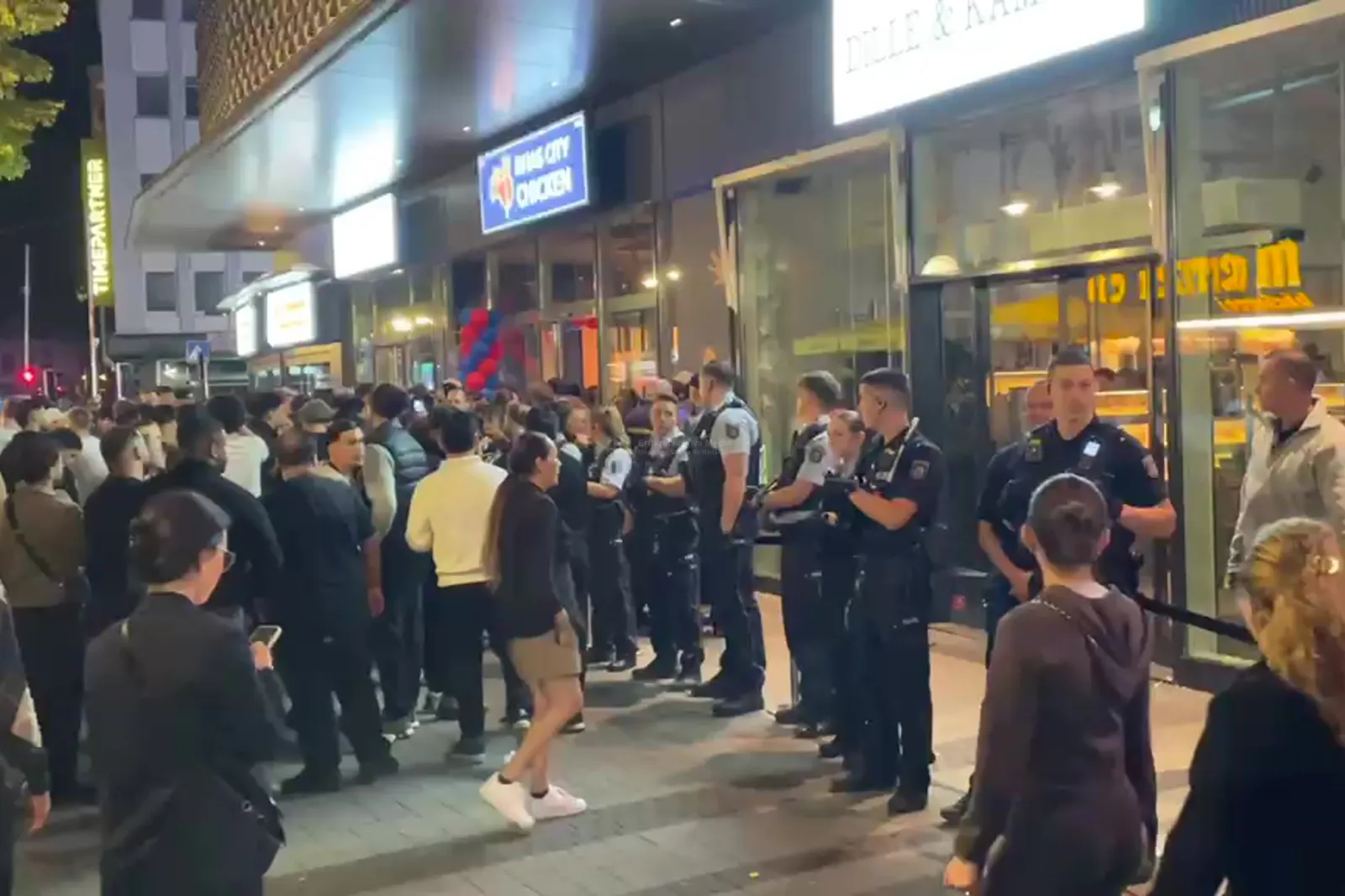 Polizei und Menschenmenge vor Nhas City Chicken in Köln