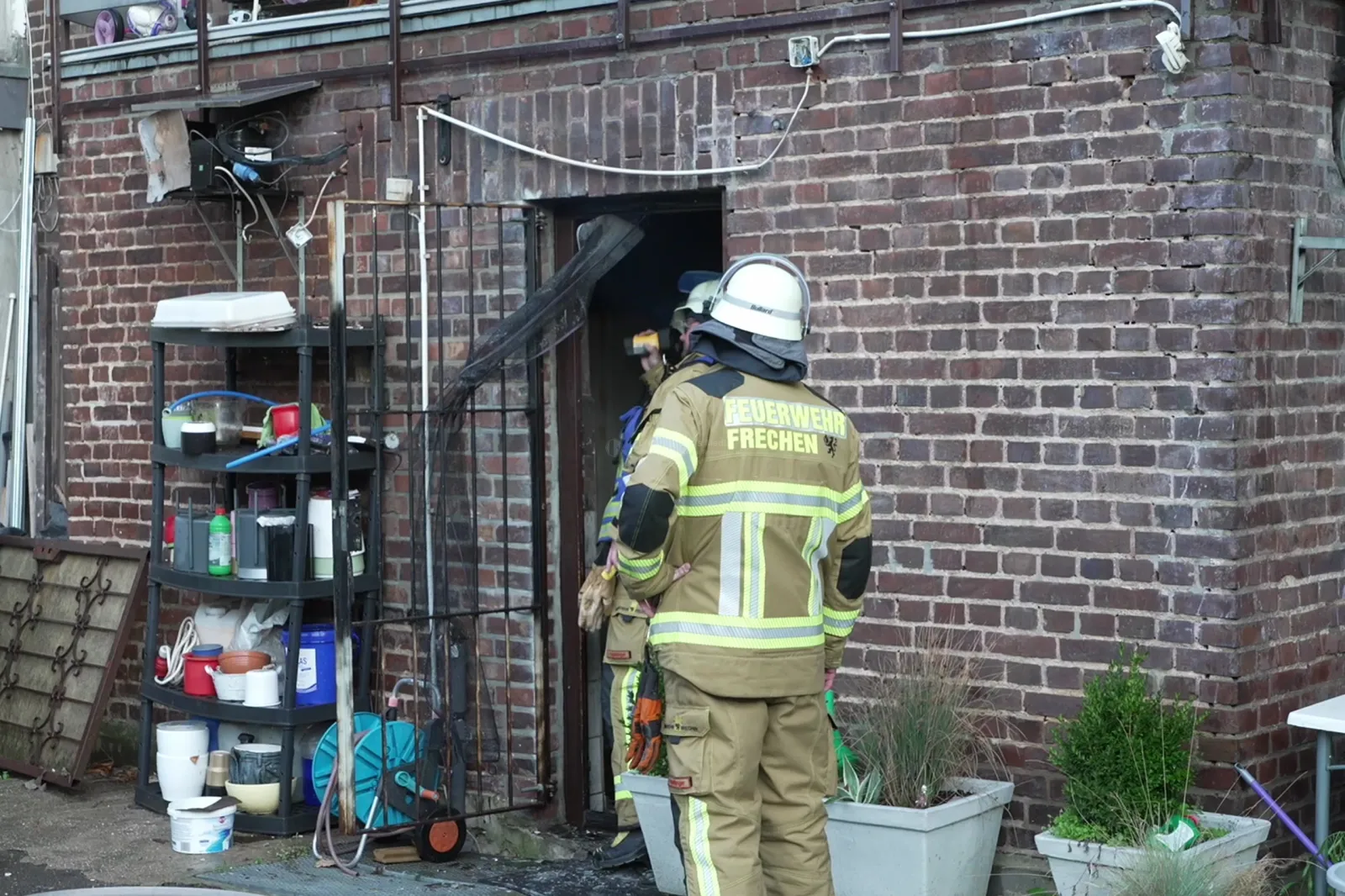 Feuerwehr Frechen vor Eingang eines Imbissgebäudes mit Backsteinwand