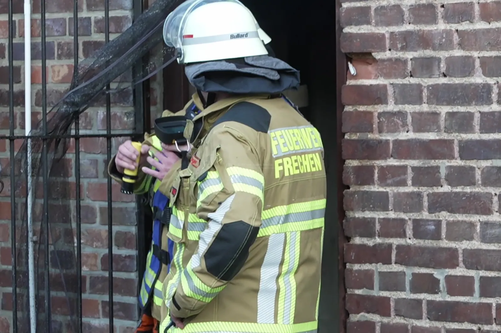 Feuerwehrmann der Feuerwehr Frechen vor Backsteinmauer