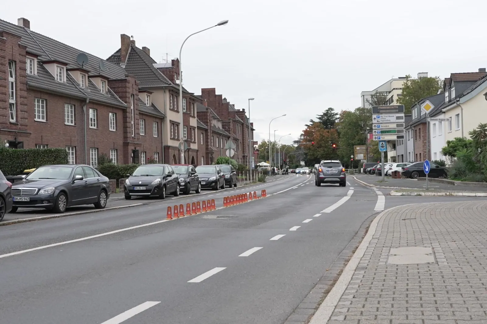 Römerstraße mit geparkten Autos und Straßenbarriere in Brühl