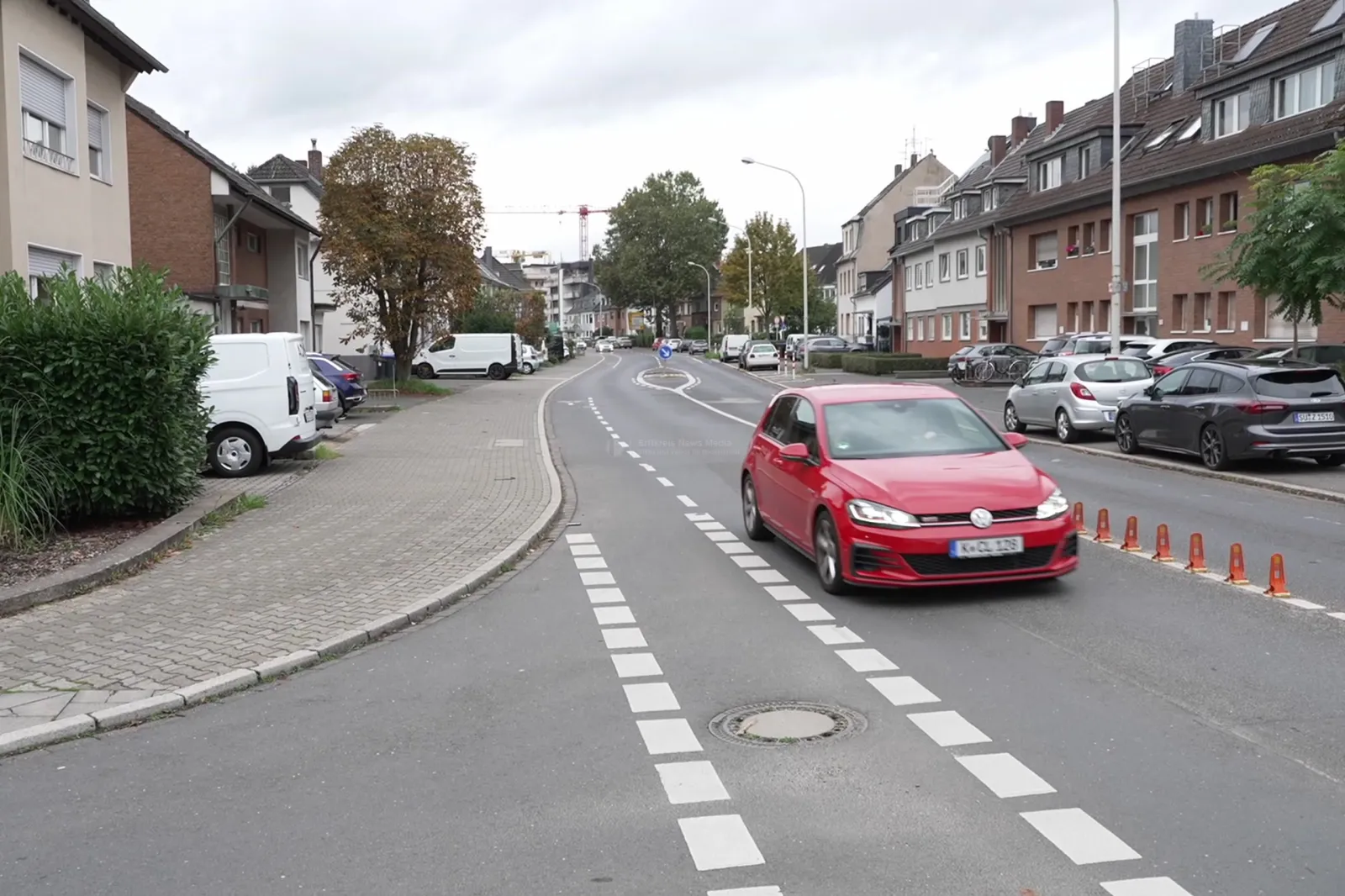 Römerstraße in Brühl mit rotem Auto auf Straße und Wohnhäusern